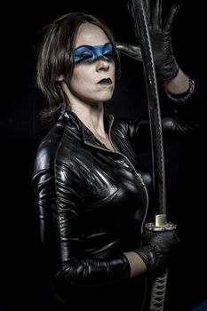 Woman with katana sword in latex costume