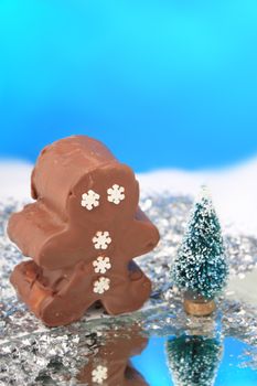 Fantasy chocolate fudge snowman in wonderland with frozen pond and snow