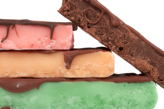 Four stacked fudge bars in different color and flavors like mint, orange, chocolate and strawberry on a white background