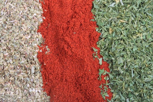 Close up of three different spices, being paprika, parsley flakes and oregano