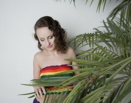 woman in a rainbow clothing under a palm tree in the Studio