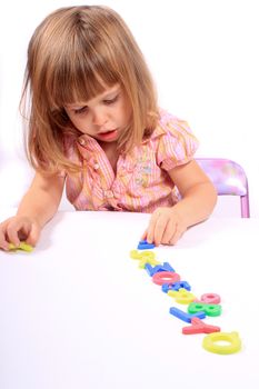 Young girl playing with letters and numbers for early childhood development