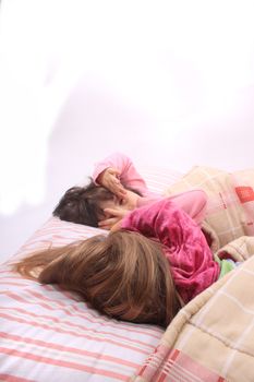 Sleepy little girls just waking up in bed