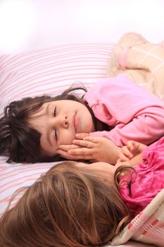 Sleepy little girls just waking up in bed