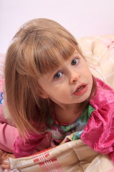 Sleepy little girl just waking up in bed cozy with blanket and messy hair