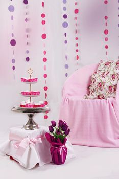 Pink baby shower decor with garland and dessert table