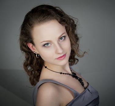 woman in a grey dress with a grey background