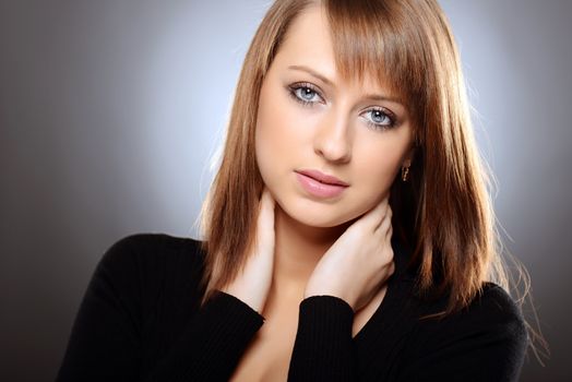 Beautiful brown haired woman posing over grey background