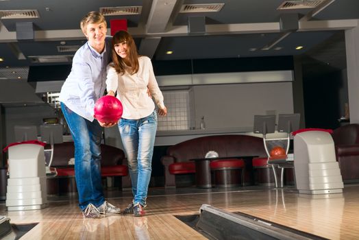 guy hugs her friendgirl, playing together in bowling