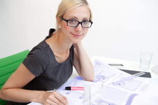Business woman with blueprint at workplace