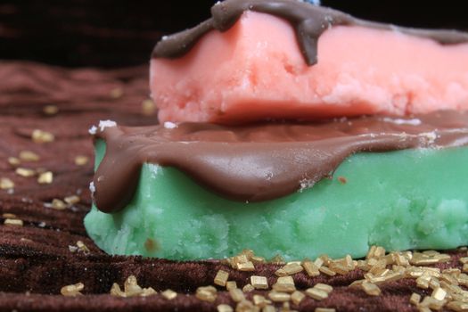 Strawberry pink, and mint green fudge bars covered in chocolate with gold flakes 