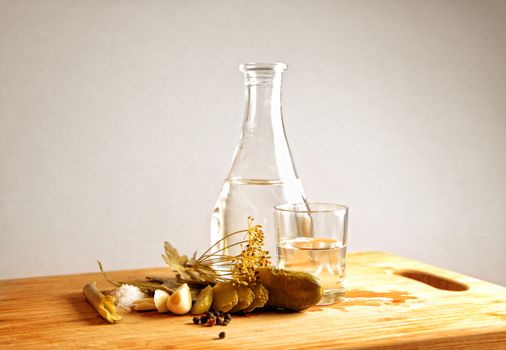 Pickled cucumber still life on old plank. Traditional russian appetizer to vodka