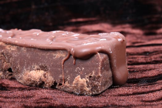 Piece of chocolate fudge on a rich brown background