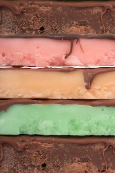 Close up of fudge bar pile in different colors and flavors covered in chocolate