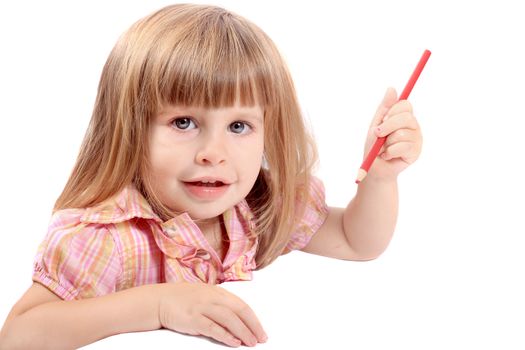 Cute little two year old girl draws pictures on white paper looking and smiling at camera