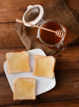 Fresh honey in glass jar on wooden background