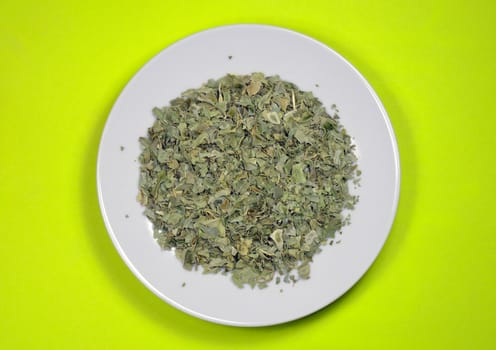 Dried green basi leavesl on white plate