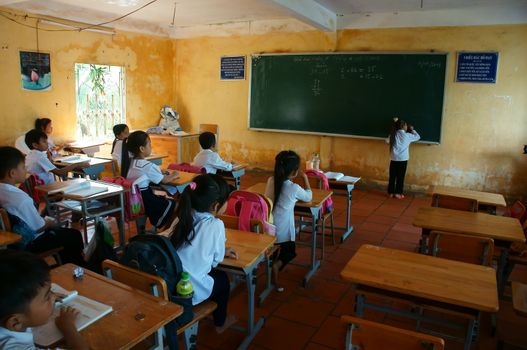 LONG AN, VIET NAM- NOV 11: Primary pupil concentrate in school time of primary school, one pupil writting on blackboard  in Long An, VietNam on Nov 11, 2013