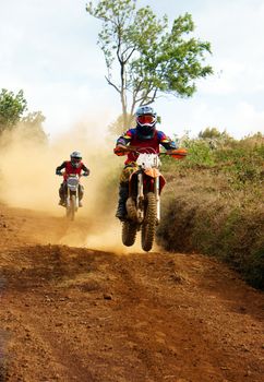 The motorcycle race hole on December at Dambri waterfall, motorcyclist try to speed up goal, red soil way, indistinct dust