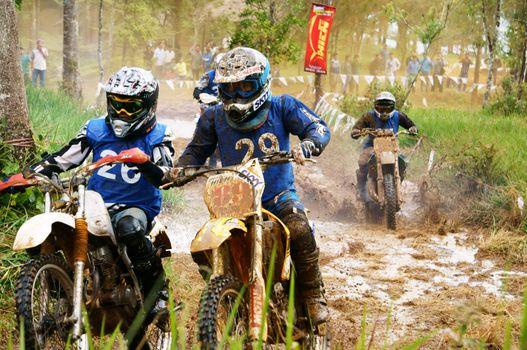 BAO LOC, VIET NAM- DECEMBER 23 Racer in activity at motorcycle race hole on Bao Loc, Viet Nam, they try to across a marshy stretch of road with violent competition in December 23, 2012                