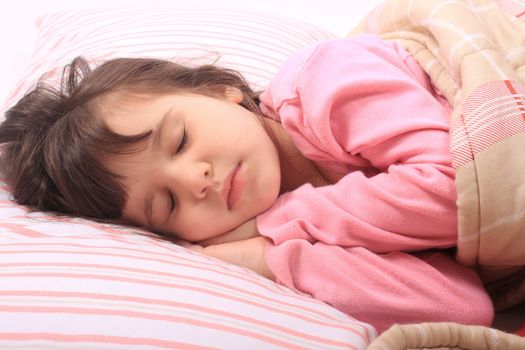 Cute little girl laying in bed sleeping cozy on her pillow and in her blanket 