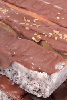 Close up of fudge bar pile in different colors and flavors covered in chocolate