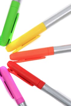 Colorful rainbow markers in orange, pink, green, yellow and red on a white background