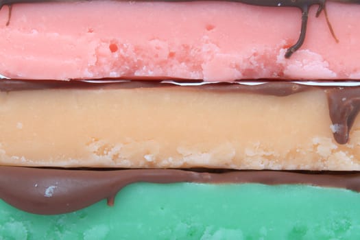 Close up of three fudge bars in three color and flavors like mint, orange and strawberry on a white background