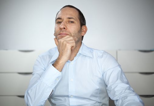 mature well dressed businessman is pointing into the camera