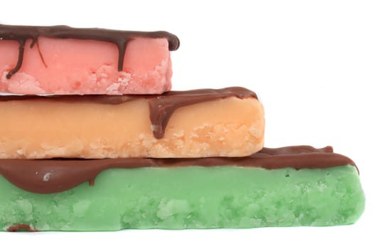 Three fudge bars in three color and flavors like mint, orange and strawberry on a white background