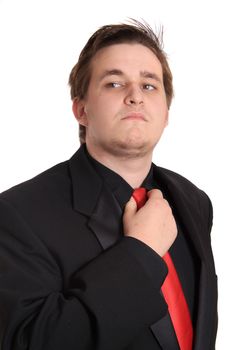 Cocky young businessman loosening his red tie on a white background