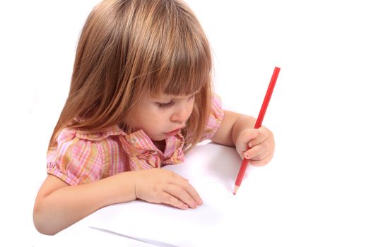 Cute little two year old girl draws pictures on white paper