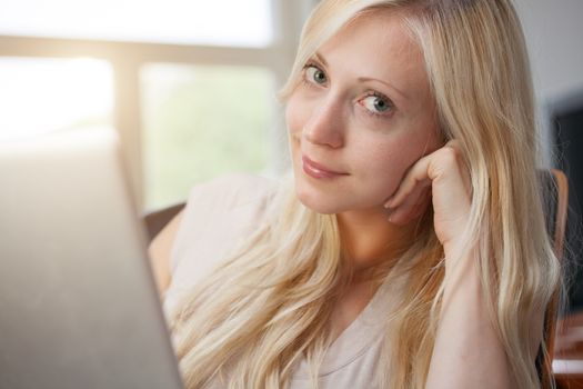 Pretty blond woman sitting with laptop