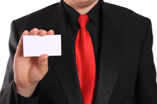 Businessman holding a blank business card in one hand showing his black suit and red tie (focus on card)