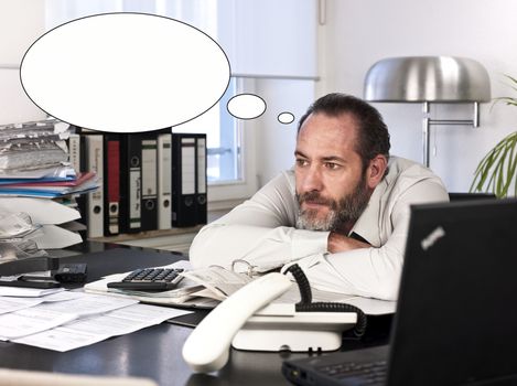 Mature businessman at desk with a thought bubble. Horizontal shot