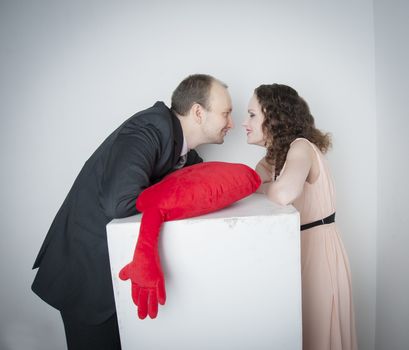 man and woman holding a red heart