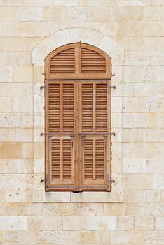 Closed window of the old building covered by wooden blinds