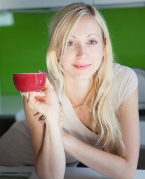Young woman has her coffee break at home