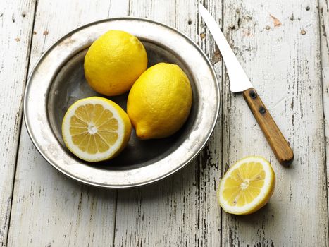 ripe tasty lemon in old steel plate on wooden table