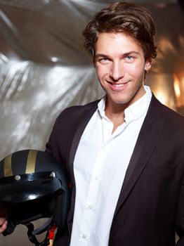 Portrait of an attractive young businessman - smiling while holding a motorcycle helmet