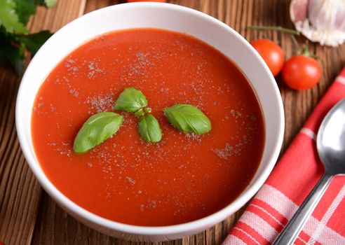 Tasty tomato soup on wooden background