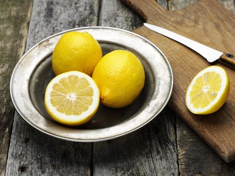 fresh ripe lemons in the steel plate on wooden board