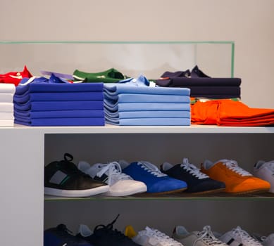 View of Polo shirts and sport shoes in a clothes shop