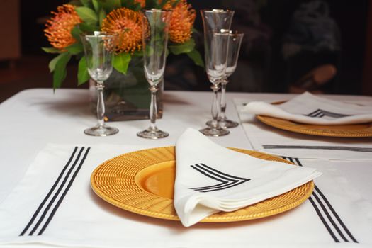 View of elegant table set with orange flowers