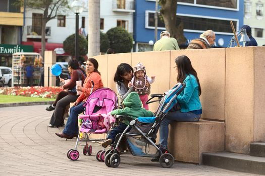 LIMA, PERU - SEPTEMBER 26, 2011: Unidentified young mother with child in Parque Kennedy on September 26, 2011 in Miraflores, Lima, Peru. Many young women have children at an early age in Peru. 