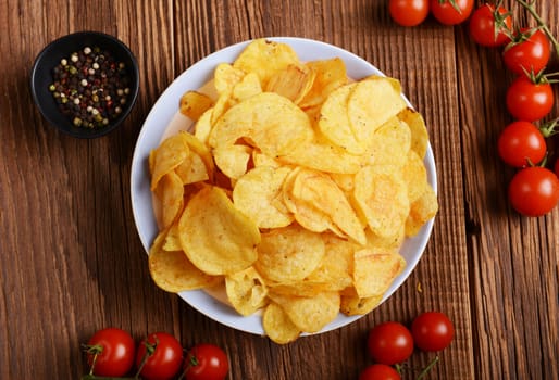 Potato chips on wooden background