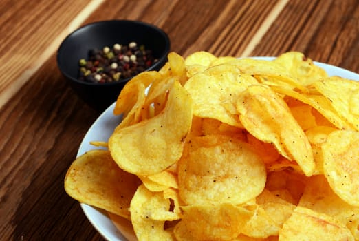 Potato chips on wooden background
