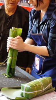 HO CHI MINH CITY, VIET NAM- JAN 15: Singer Phi Nhung make traditional food in competition, the cake cover by green bananna leaf in Ho Chi Minh, Vietnam on Jan 15, 2013