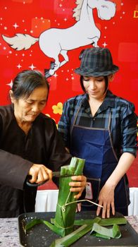 HO CHI MINH CITY, VIET NAM- JAN 15: Singer Phi Nhung make traditional food in competition, the cake cover by green bananna leaf in Ho Chi Minh, Vietnam on Jan 15, 2013