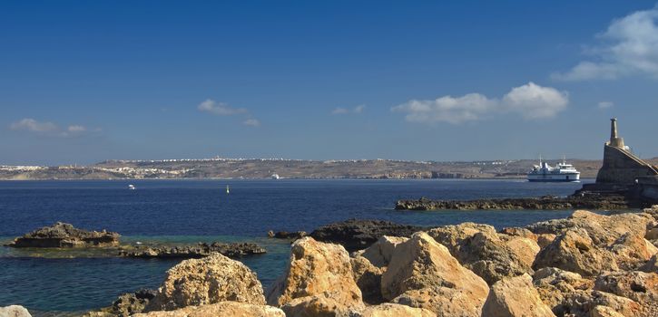 Rocky shore in the northwest Malta and panoramic view of Gozo island in the background - Cirkewwa, Malta